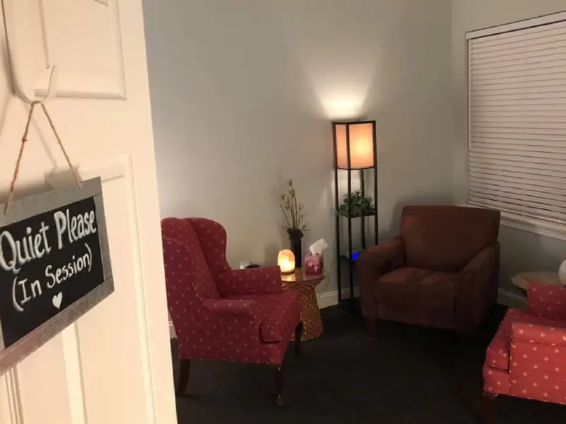 A living room with two chairs and a lamp