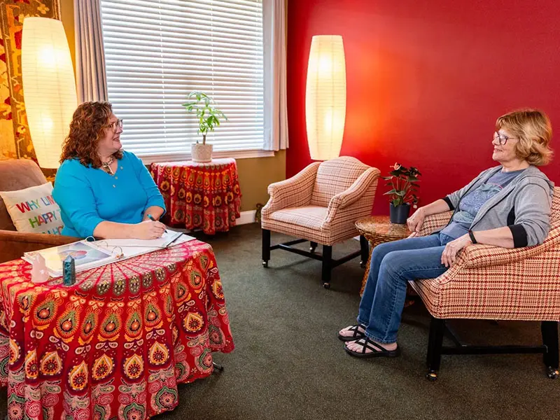 Two people sitting in a room talking to each other.