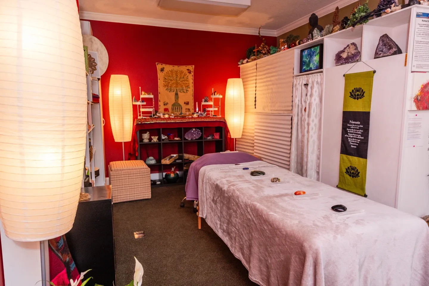 A room with two beds and a red wall